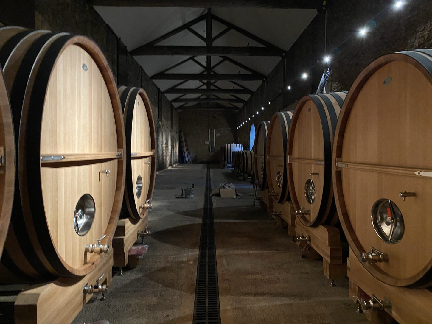 Éclairage d’un chai avec grands foudres en bois