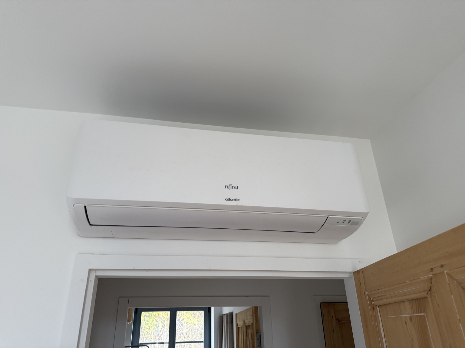 Unité intérieure de climatisation Atlantic Fujitsu installée au-dessus d’une porte